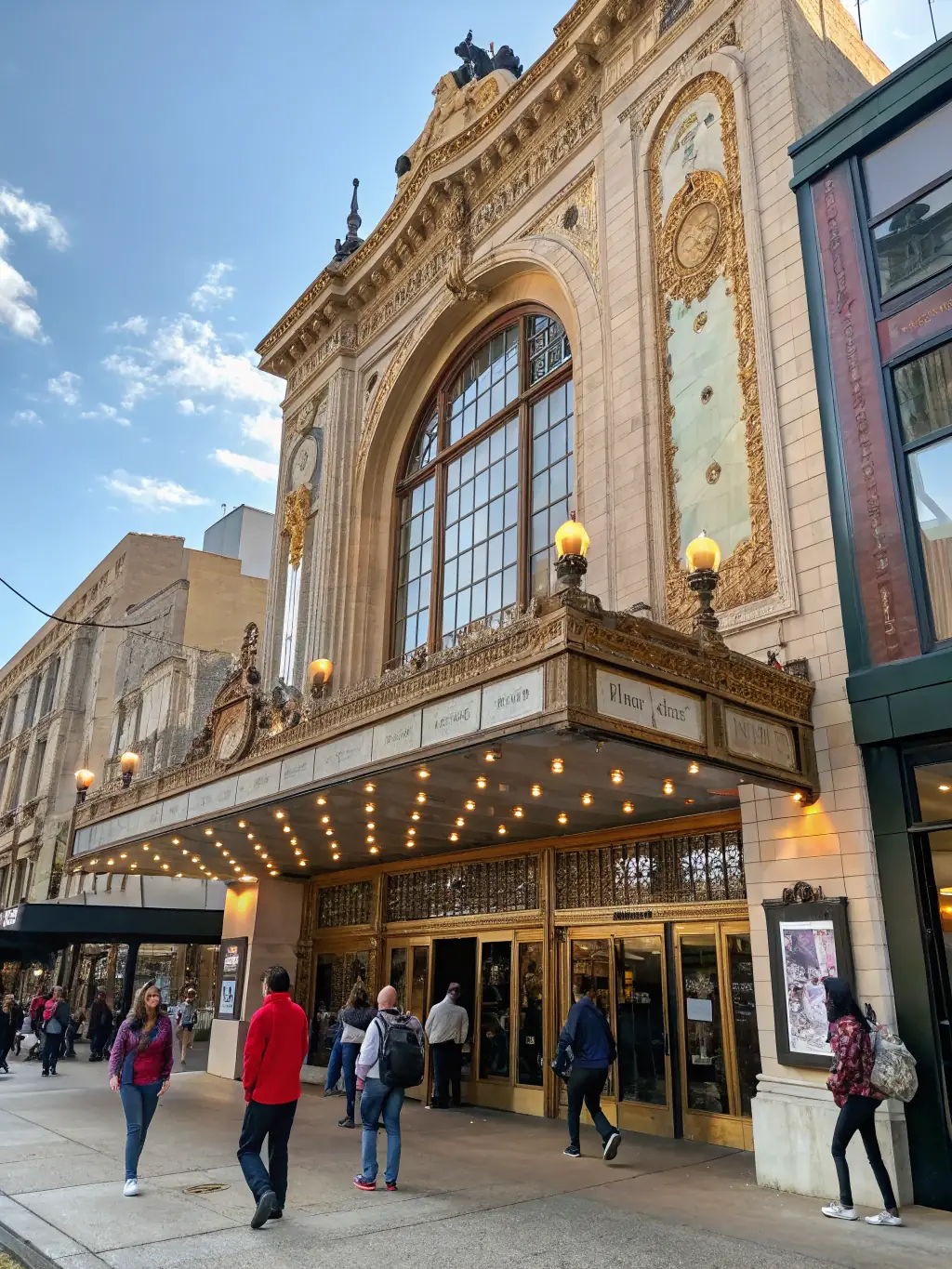A photograph of a beautifully restored historic theater, now serving as a vibrant community arts center, showcasing the successful revitalization of a local landmark.